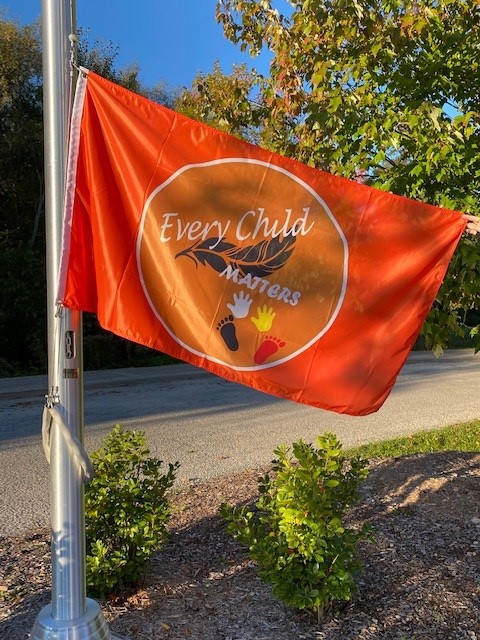 Orange flag with every child matters on it