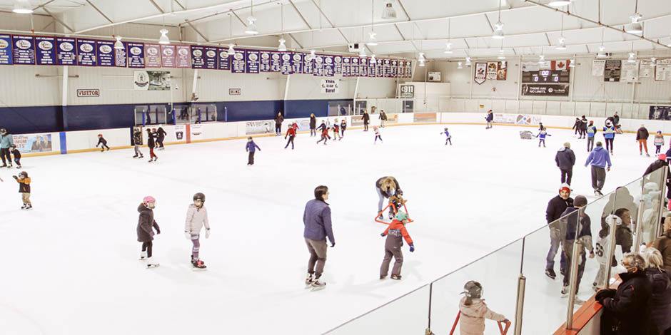 People skating indoors at a hockey rink