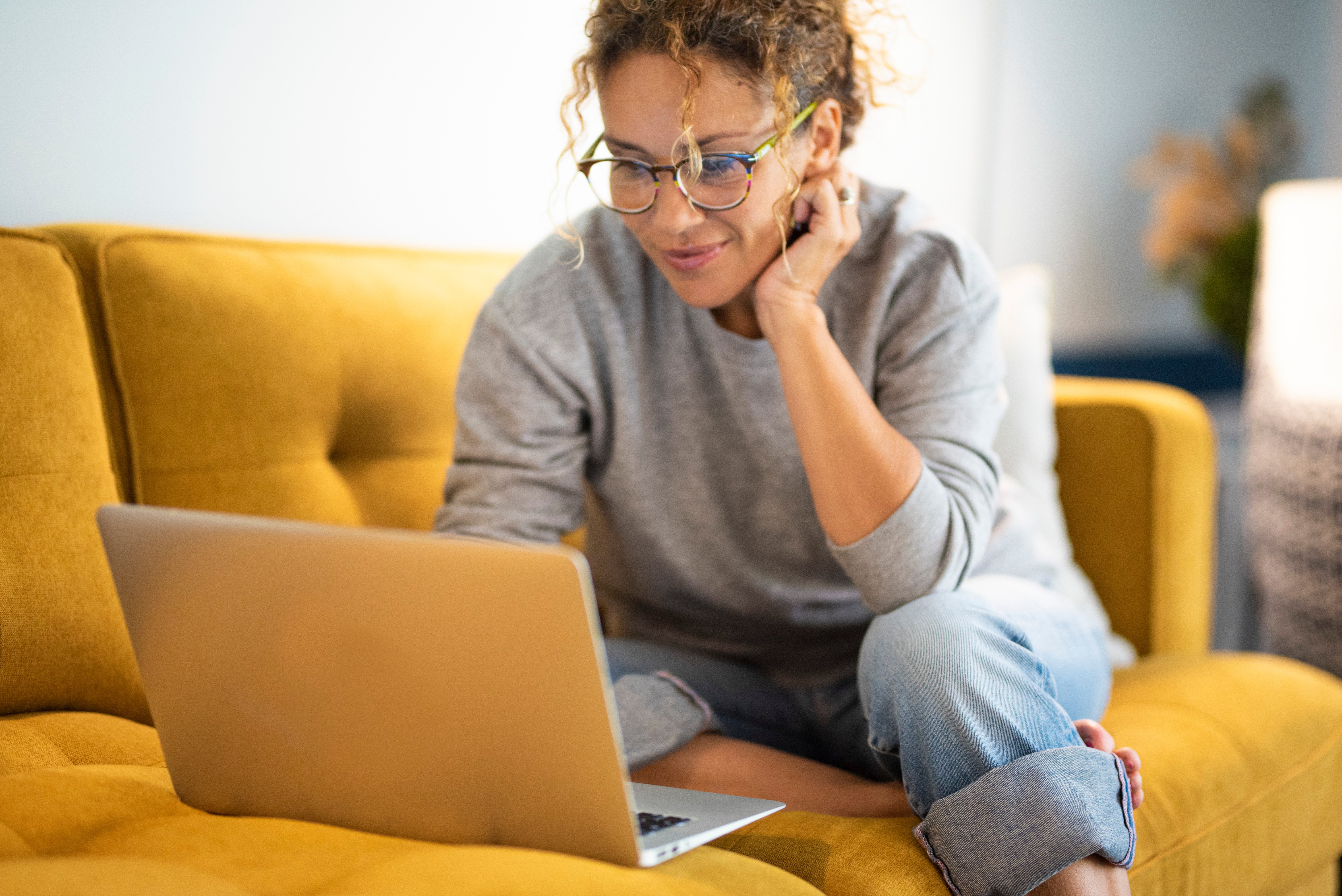 Woman sitting on couch on a laptop