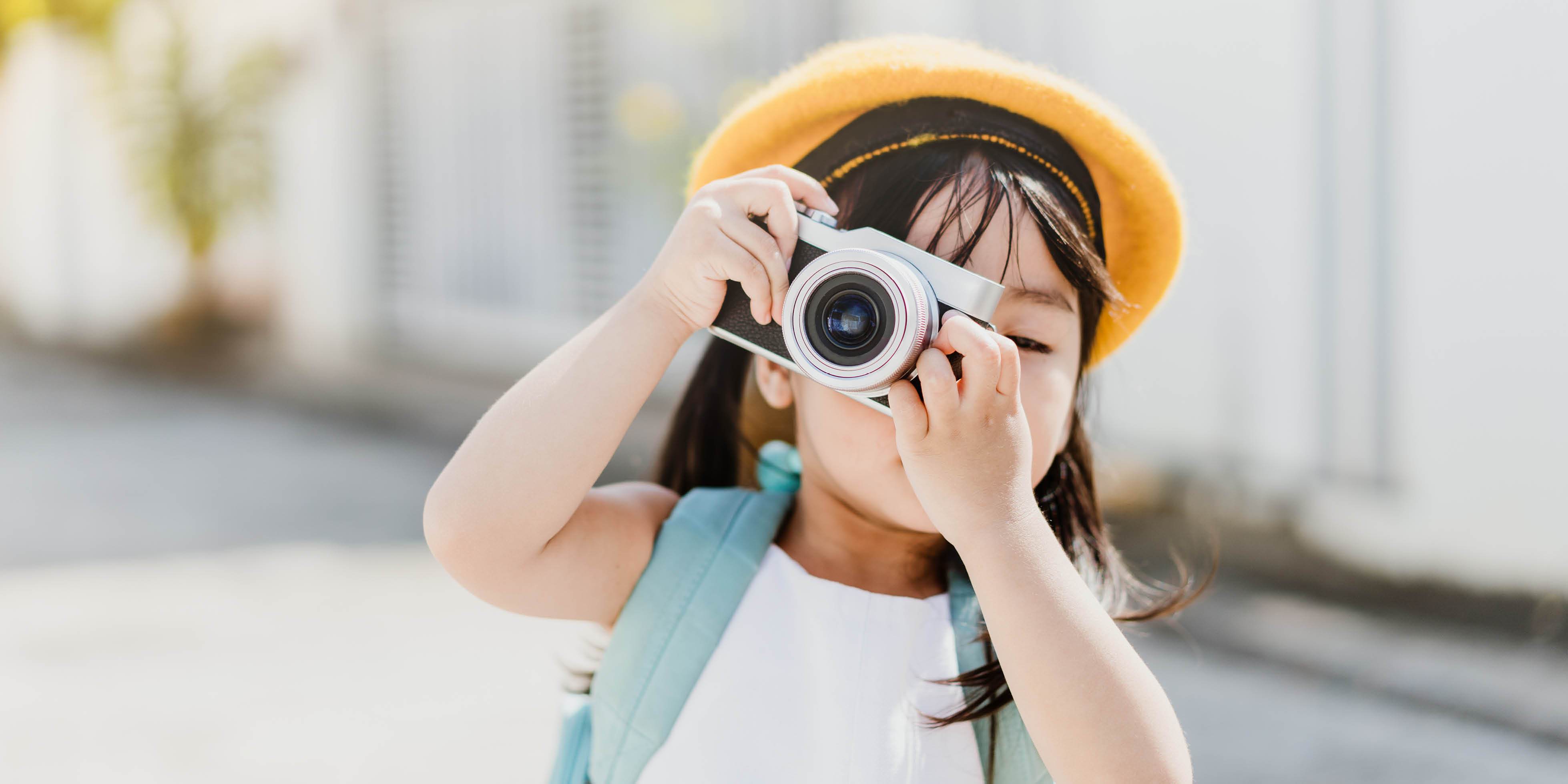 Asian little girl taking photo with camera