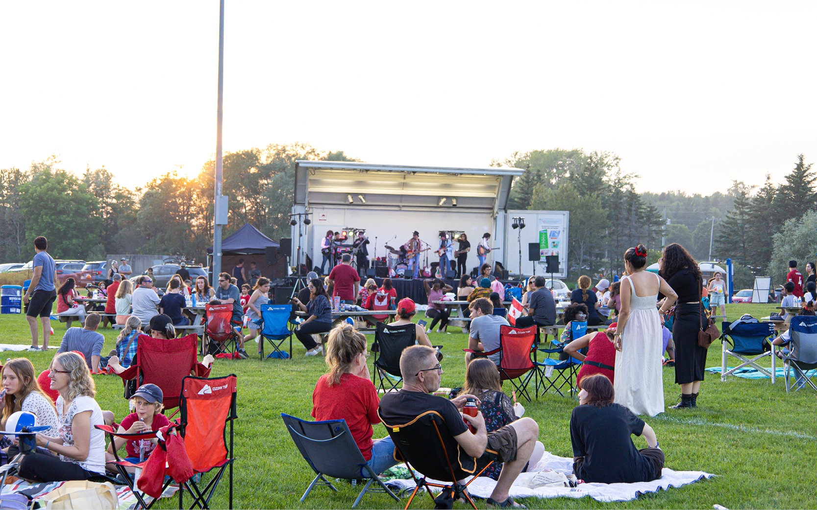 People sitting on lawn by stage