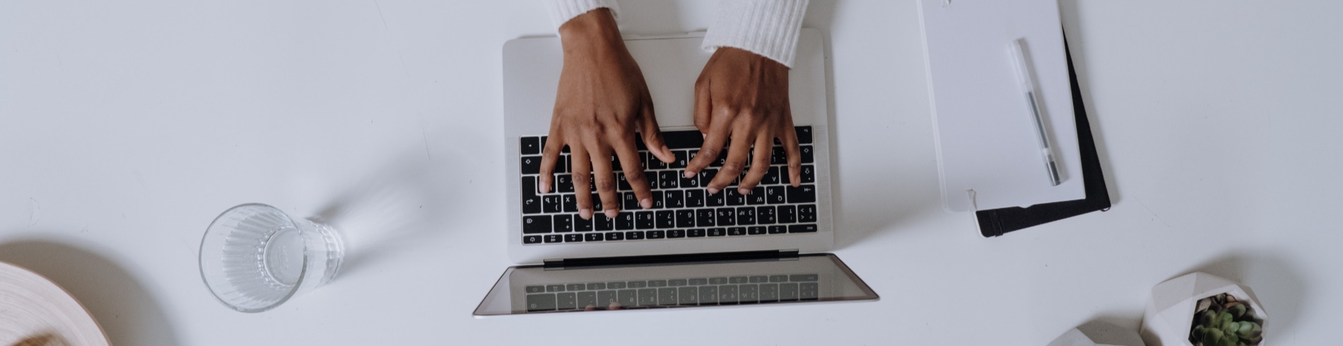 Hands typing on a laptop