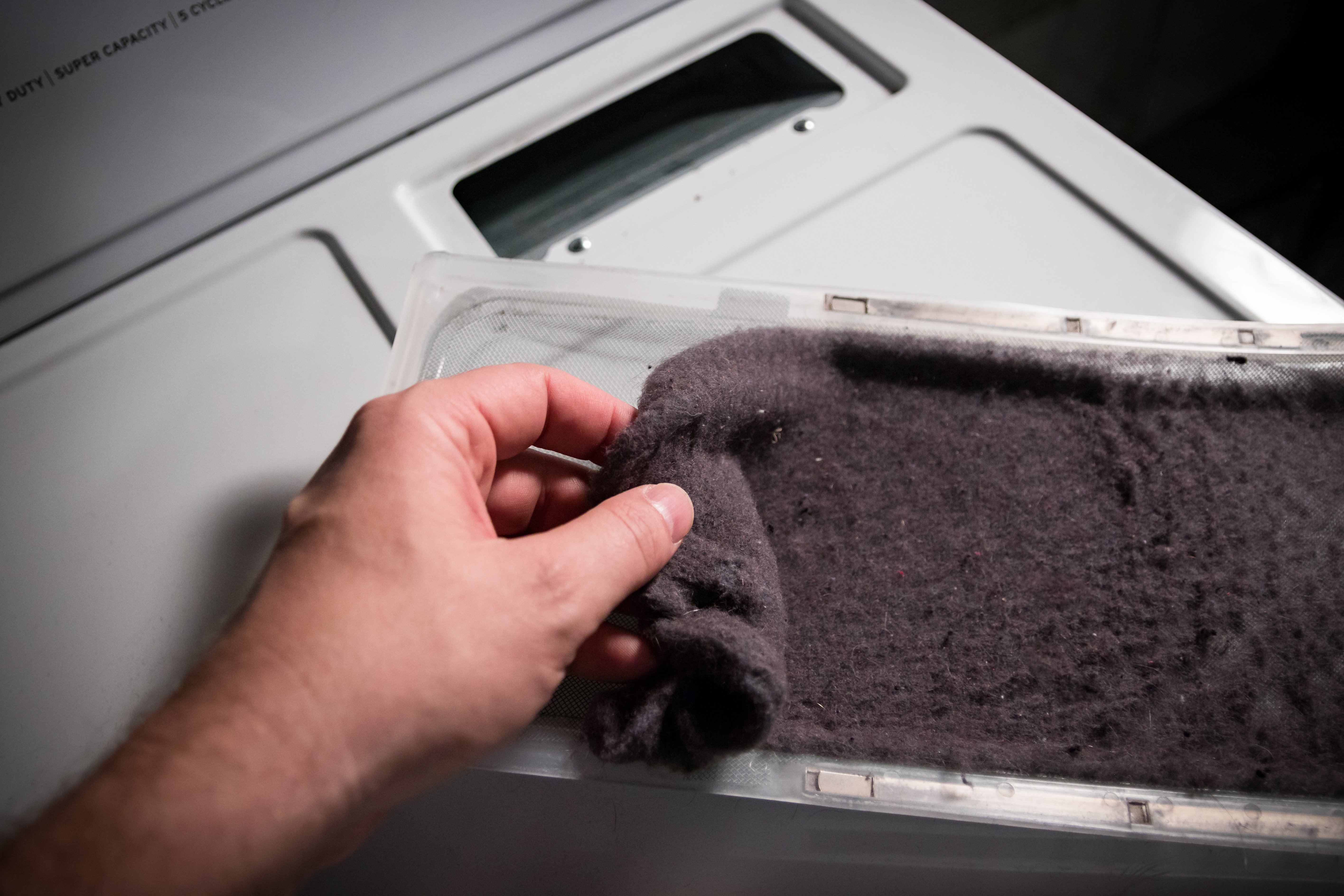 Hand cleaning lint out of the dryer catch vent