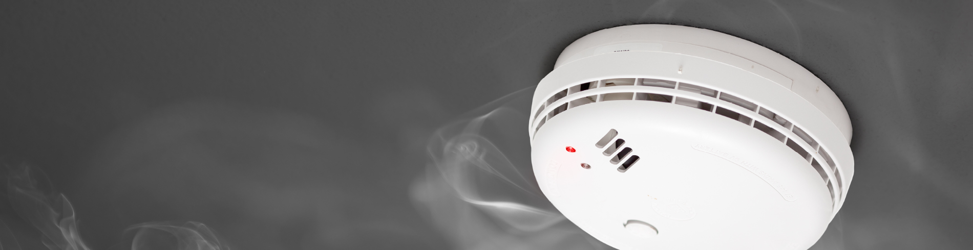 Smoke Alarm with smoke on grey background