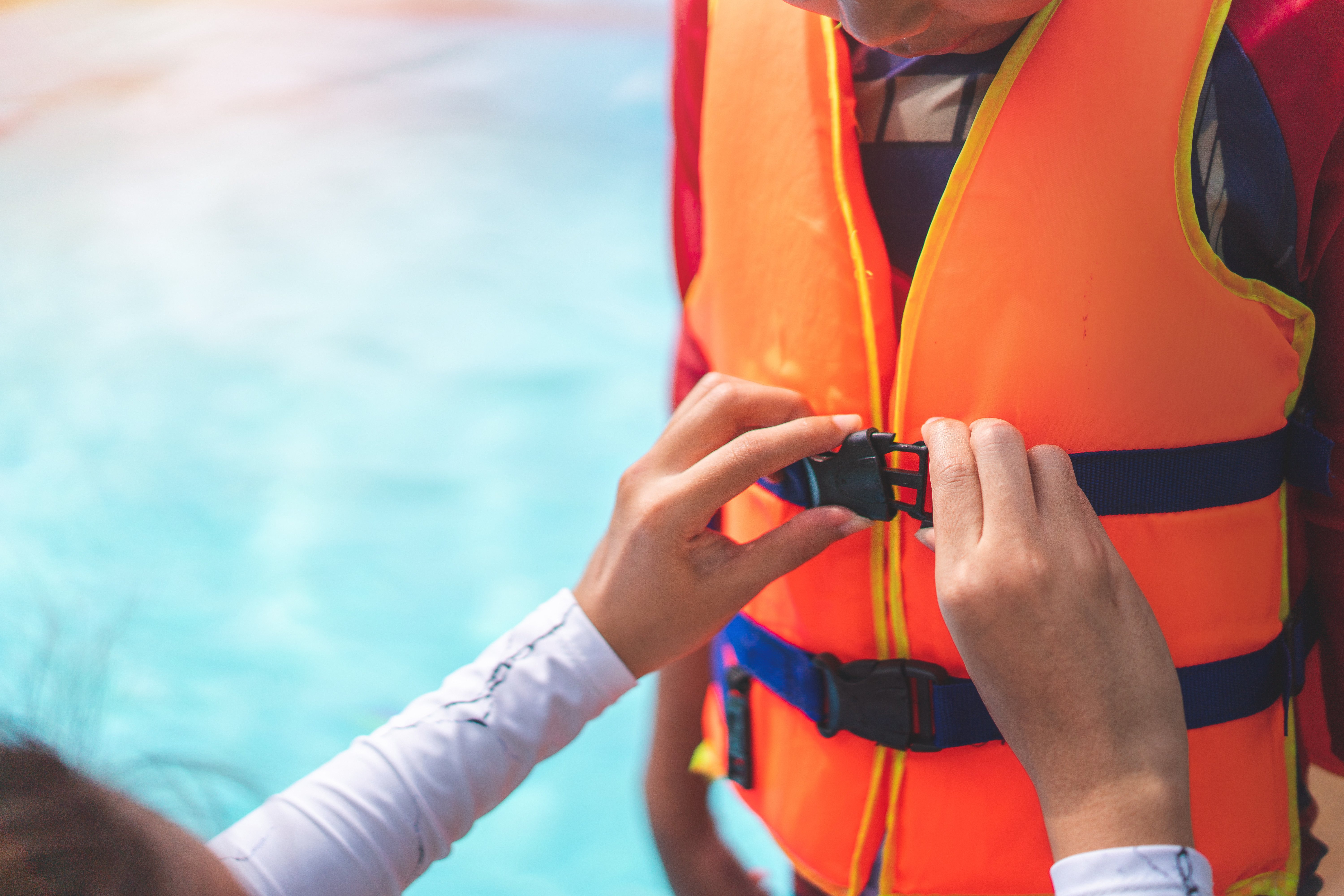Adult helping child secure lifejacket