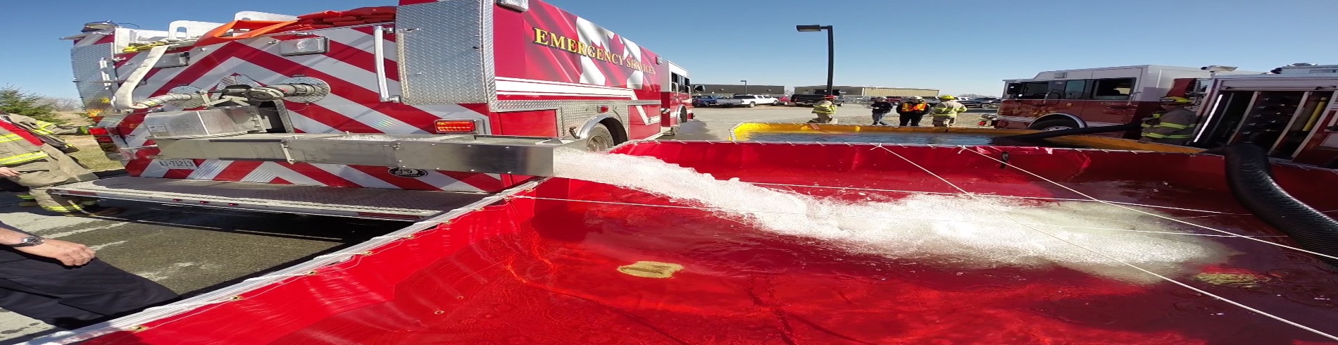 Fire fighters fill portable tanks with water as part of the Tanker Shuttle Service
