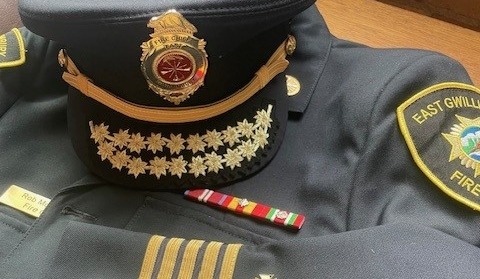 Fire Chief jacket and hat laying on table