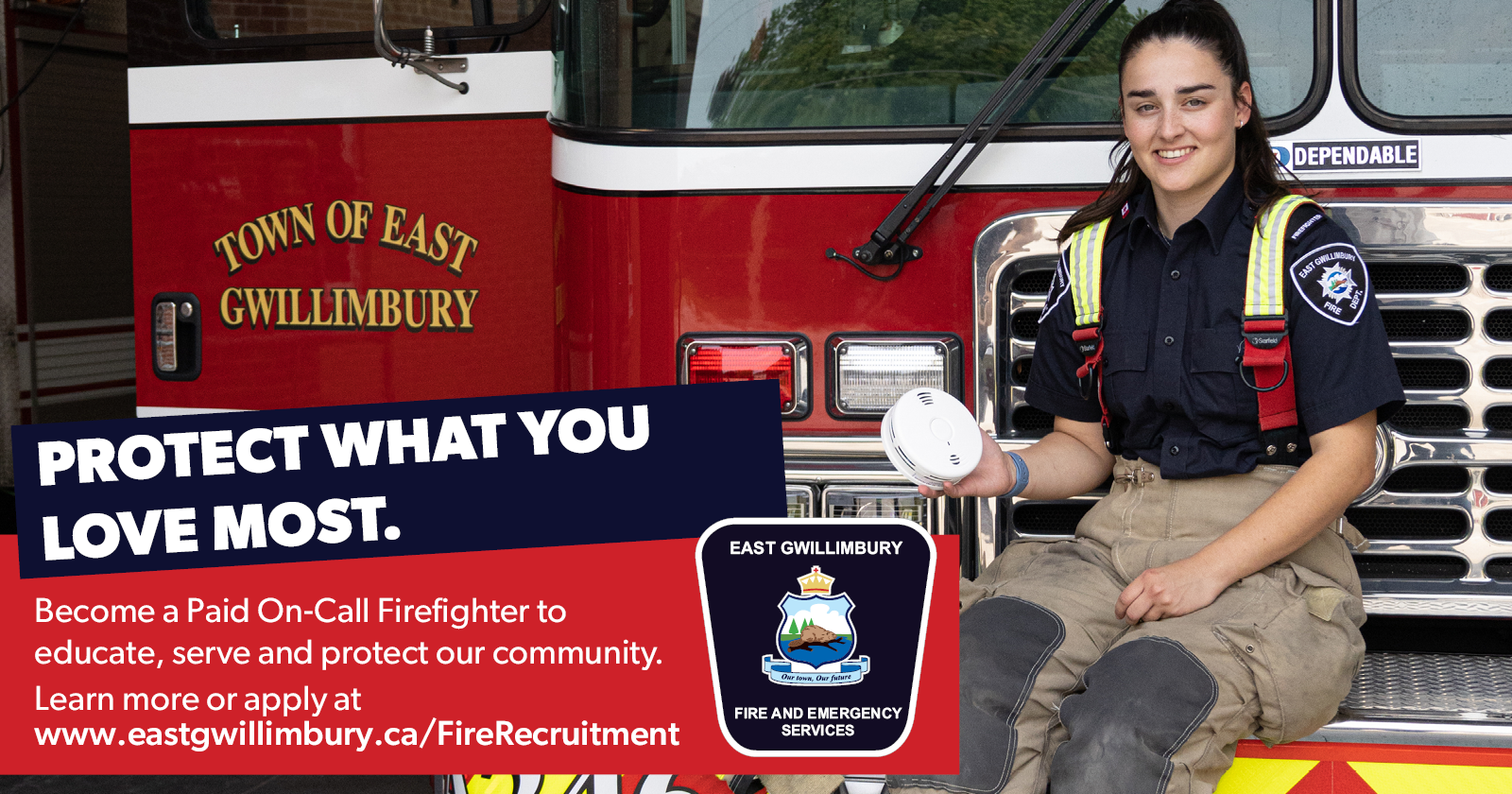 Person sitting on the front of a firetruck holding a smoke alarm