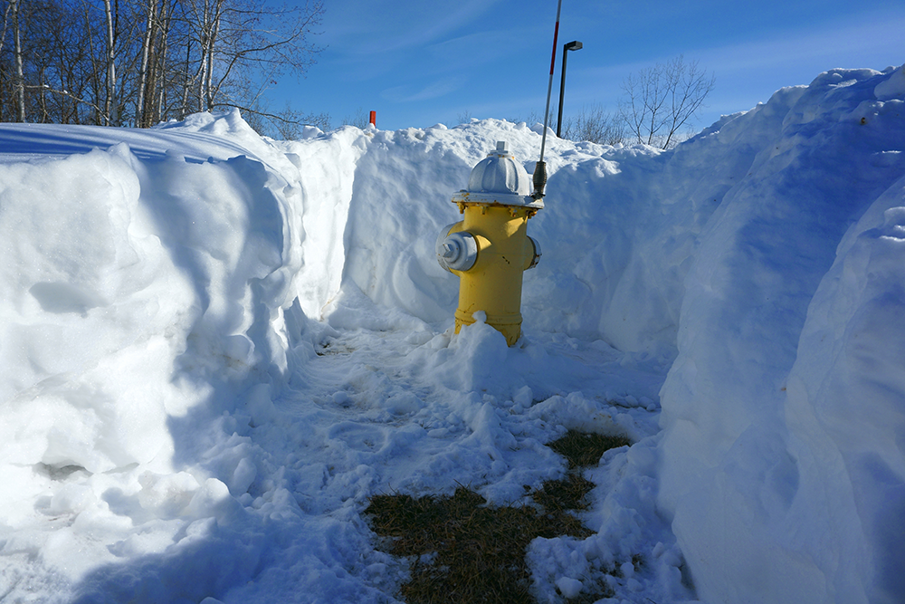 Yellow fire hydrant with snow cleared from around it