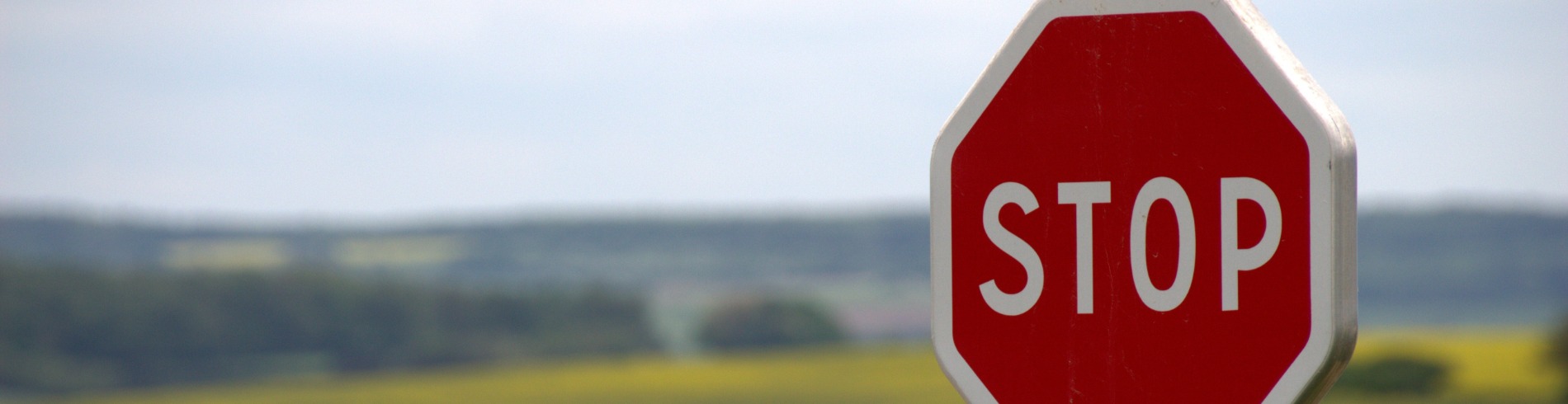 Stop sign in front of fields